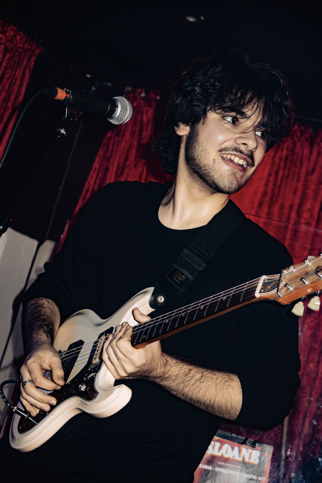 Zoning Out guitarist performing live in front of red curtains